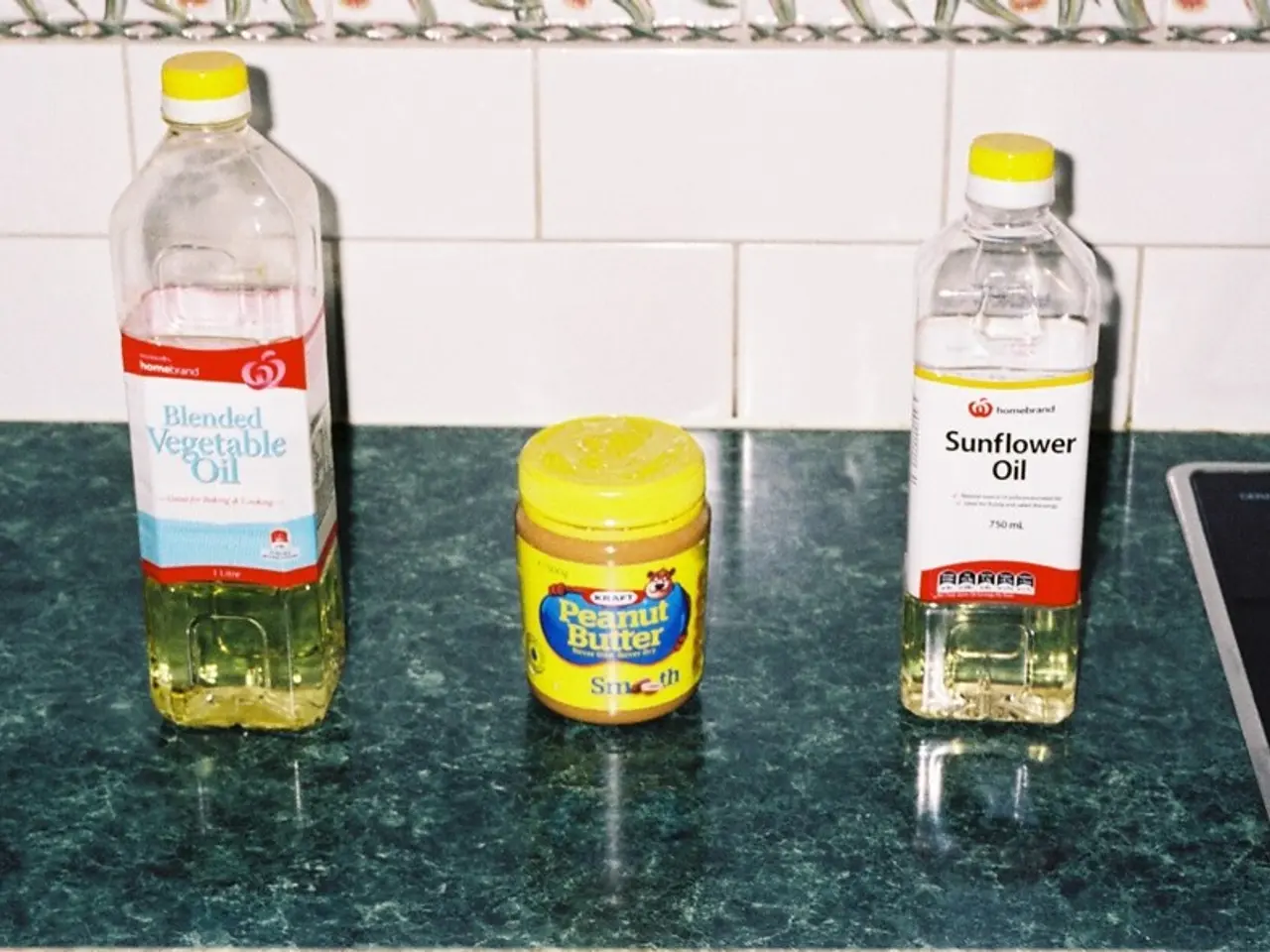 In this image there are three bottles placed on a table. Both the ends there are oil bottles but in...