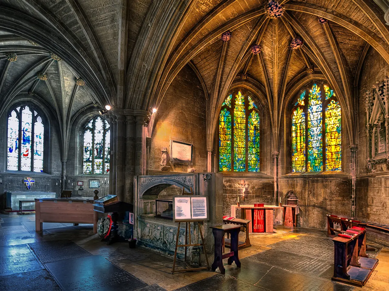 This is a picture of a building. On the right there are benches, desk, board, windows and wall. On...