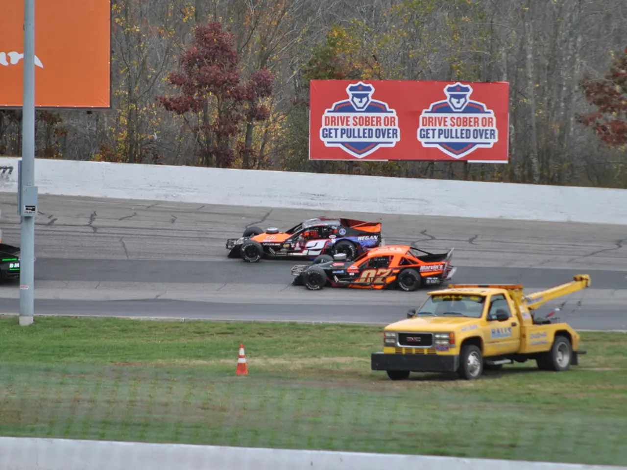 In this image in the center there are some vehicles, and at the bottom there is a walkway and...