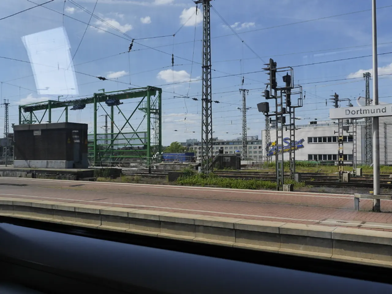In this picture I can observe railway platform. There are some wires in the middle of the picture....