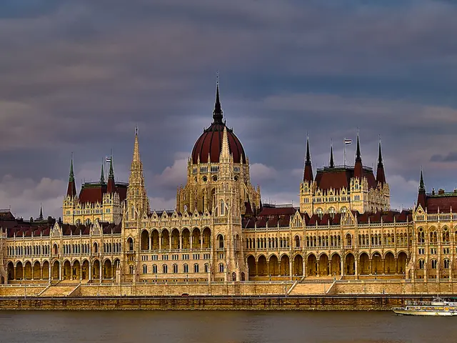 Sky is cloudy. Ship is floating on water. Buildings with windows. Beside this buildings there are...