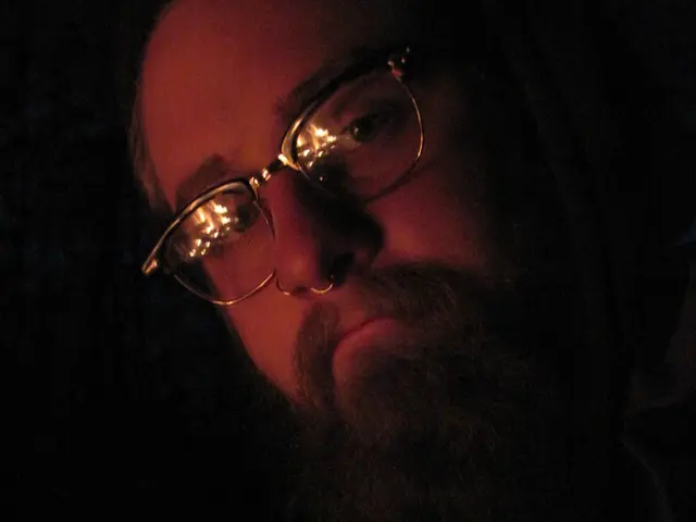 This describe about close view of the men wearing specs with big beard is giving a pose into the...