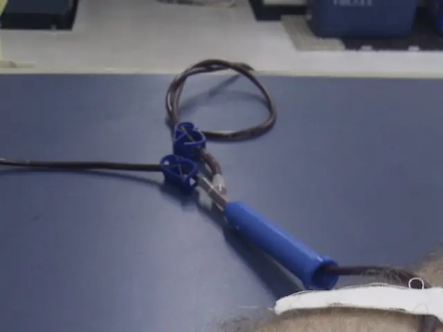 In this image we can see hand of a person with saline tube with needle. Also there are plasters.