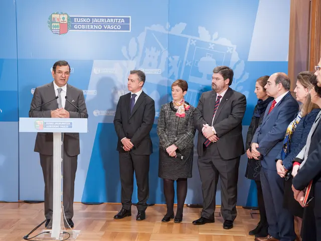 In this image a person wearing suit and tie is standing behind the podium having miles on it....