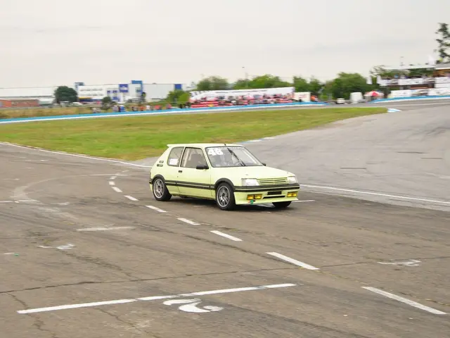 It is a car which is moving on the road, it is in green color, there are buildings in the long back...